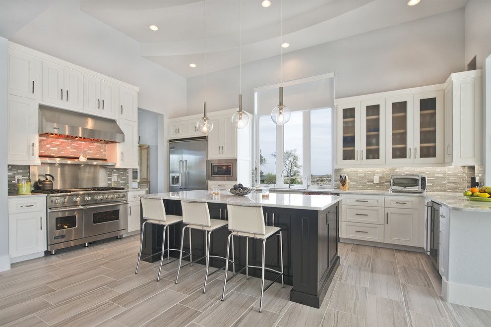 This is an example of a transitional l-shaped kitchen in Austin with recessed-panel cabinets, white cabinets, grey splashback, stainless steel appliances, with island and grey floor.