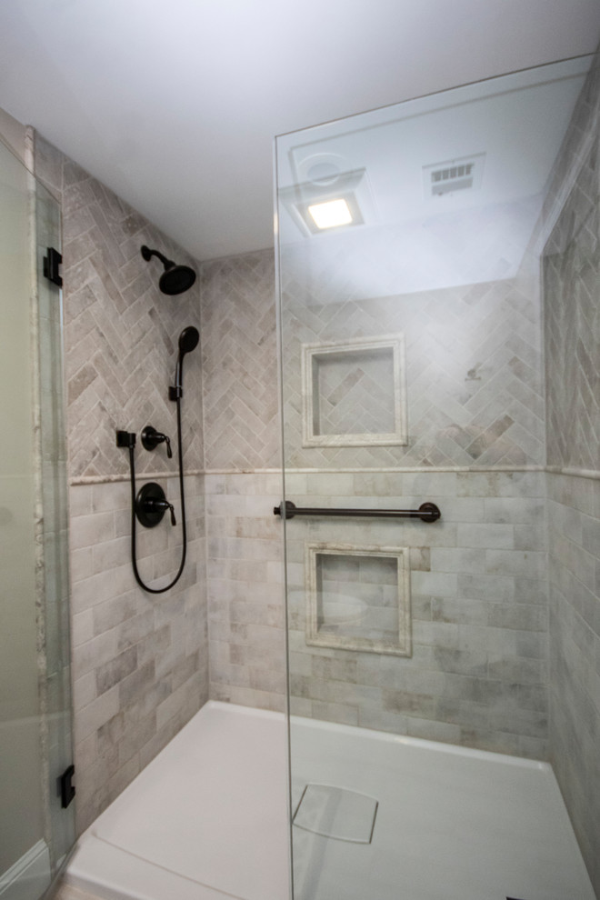 Photo of a mid-sized traditional master bathroom in Boston with recessed-panel cabinets, grey cabinets, an alcove shower, a two-piece toilet, gray tile, stone tile, grey walls, porcelain floors, an undermount sink, concrete benchtops, white floor, a hinged shower door and white benchtops.