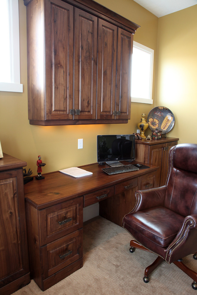 Design ideas for a mid-sized traditional home office in Salt Lake City with yellow walls, carpet, no fireplace and a built-in desk.