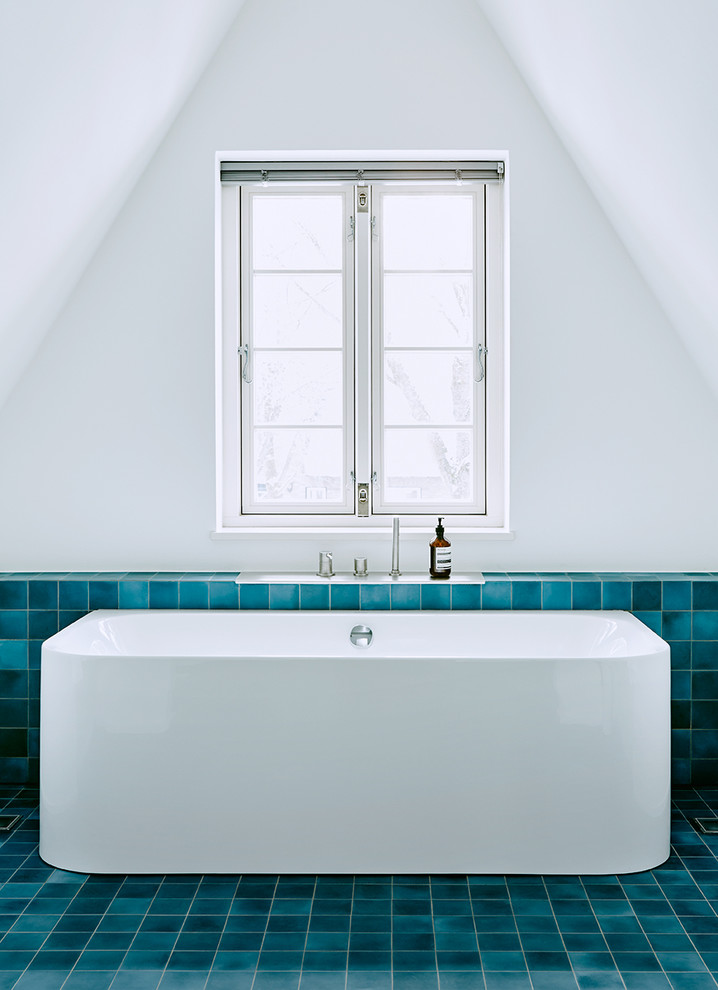 Inspiration for a mid-sized contemporary bathroom in Other with a freestanding tub, cement tile and white walls.