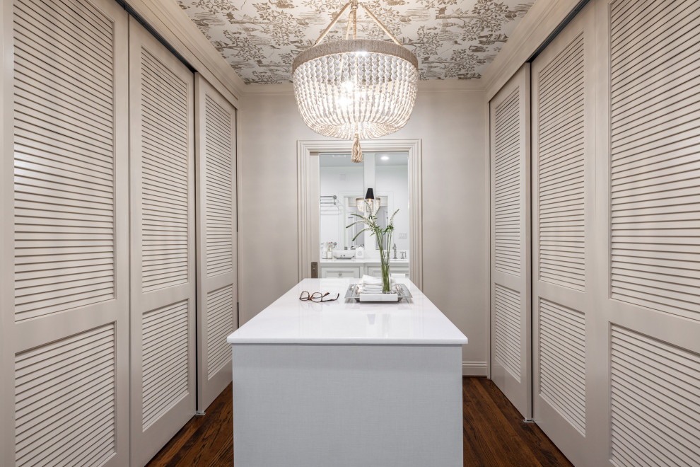 Photo of a contemporary gender neutral walk-in wardrobe in Dallas with louvered cabinets, beige cabinets, medium hardwood flooring, brown floors and a wallpapered ceiling.