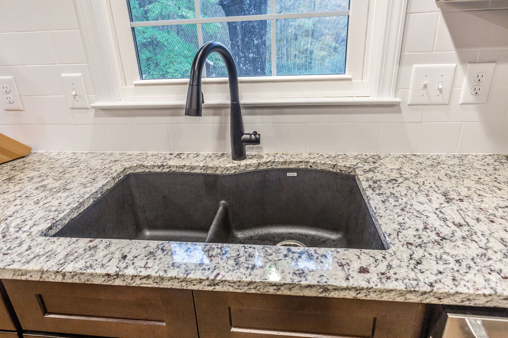 Inspiration for a mid-sized transitional l-shaped light wood floor and yellow floor eat-in kitchen remodel in Birmingham with a double-bowl sink, shaker cabinets, dark wood cabinets, granite countertops, white backsplash, subway tile backsplash, stainless steel appliances, an island and gray countertops