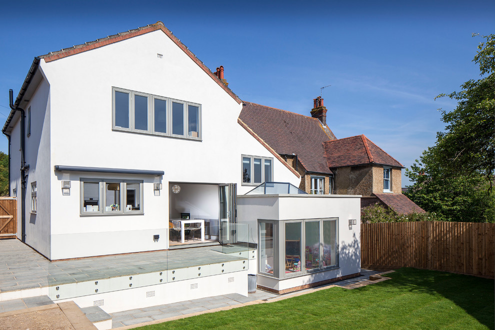 Photo of a large contemporary three-storey stucco white exterior in Hertfordshire with a gable roof.