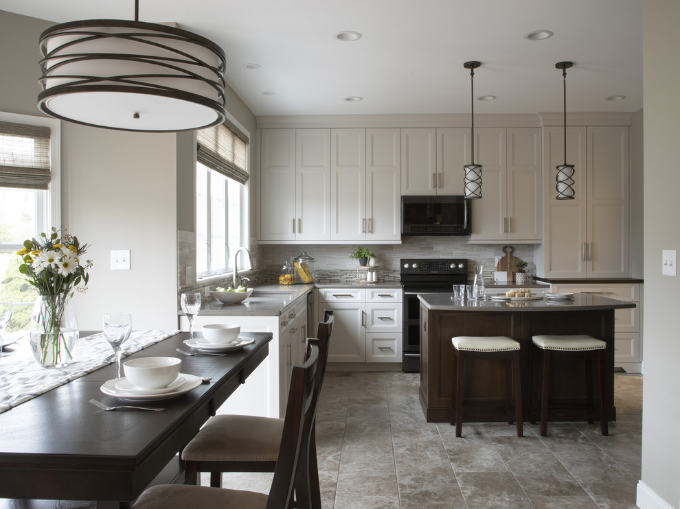 Transitional porcelain tile and beige floor kitchen photo with an undermount sink, beige backsplash, black appliances and an island