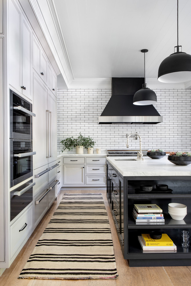 Inspiration for a large transitional kitchen in New York with grey cabinets, marble benchtops, white splashback, light hardwood floors, beige floor, white benchtop, an undermount sink, recessed-panel cabinets, stainless steel appliances and with island.