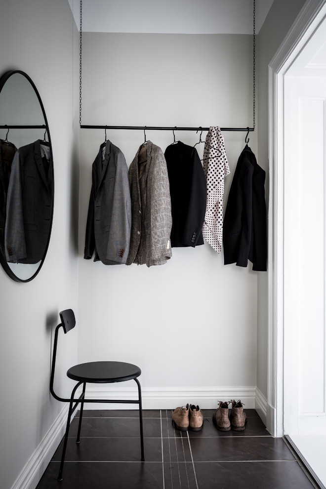Inspiration for a scandinavian gender-neutral walk-in wardrobe in Gothenburg with black floor.