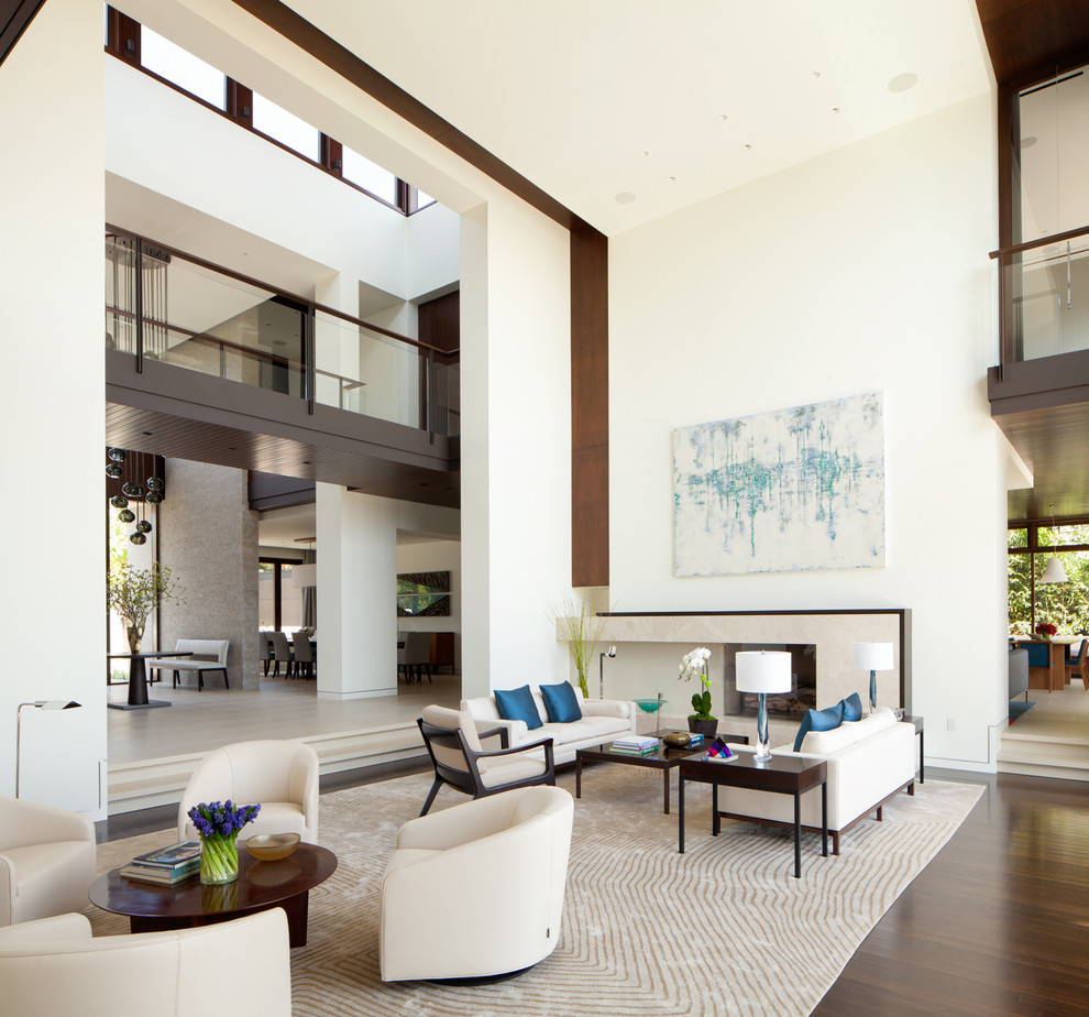This is an example of an expansive contemporary formal living room in Los Angeles with white walls, dark hardwood floors, a standard fireplace and a stone fireplace surround.