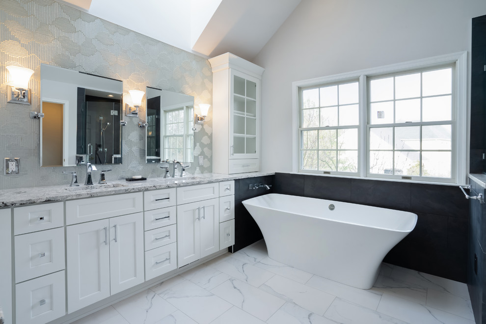 Inspiration for a mid-sized contemporary master bathroom in Philadelphia with shaker cabinets, white cabinets, a freestanding tub, an alcove shower, a two-piece toilet, black tile, glass sheet wall, grey walls, porcelain floors, an undermount sink, engineered quartz benchtops, white floor, a hinged shower door and multi-coloured benchtops.