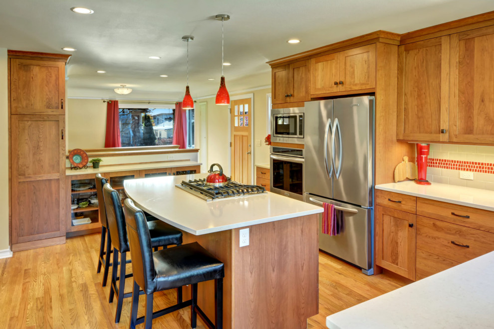 Inspiration for a l-shaped medium tone wood floor and brown floor eat-in kitchen remodel in Seattle with an undermount sink, shaker cabinets, medium tone wood cabinets, red backsplash, mosaic tile backsplash, stainless steel appliances, an island and white countertops