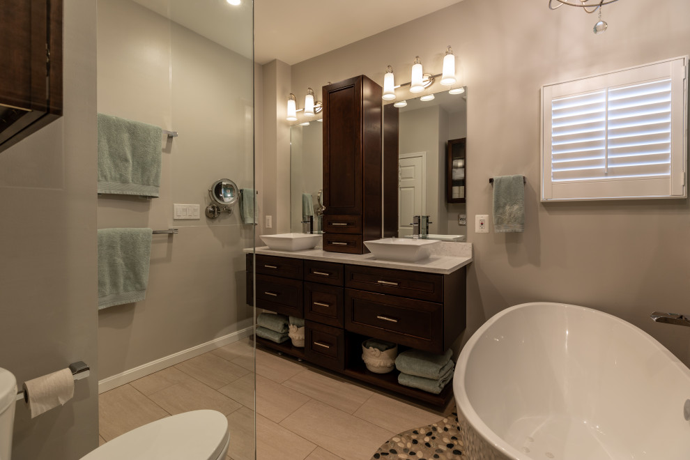 Photo of a large contemporary bathroom in DC Metro with glass-front cabinets, white cabinets, dark hardwood floors and brown floor.
