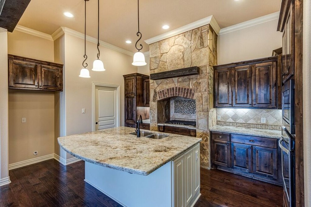 Kitchen pantry - mid-sized traditional u-shaped dark wood floor and brown floor kitchen pantry idea with an undermount sink, raised-panel cabinets, dark wood cabinets, granite countertops, beige backsplash, ceramic backsplash, stainless steel appliances and an island