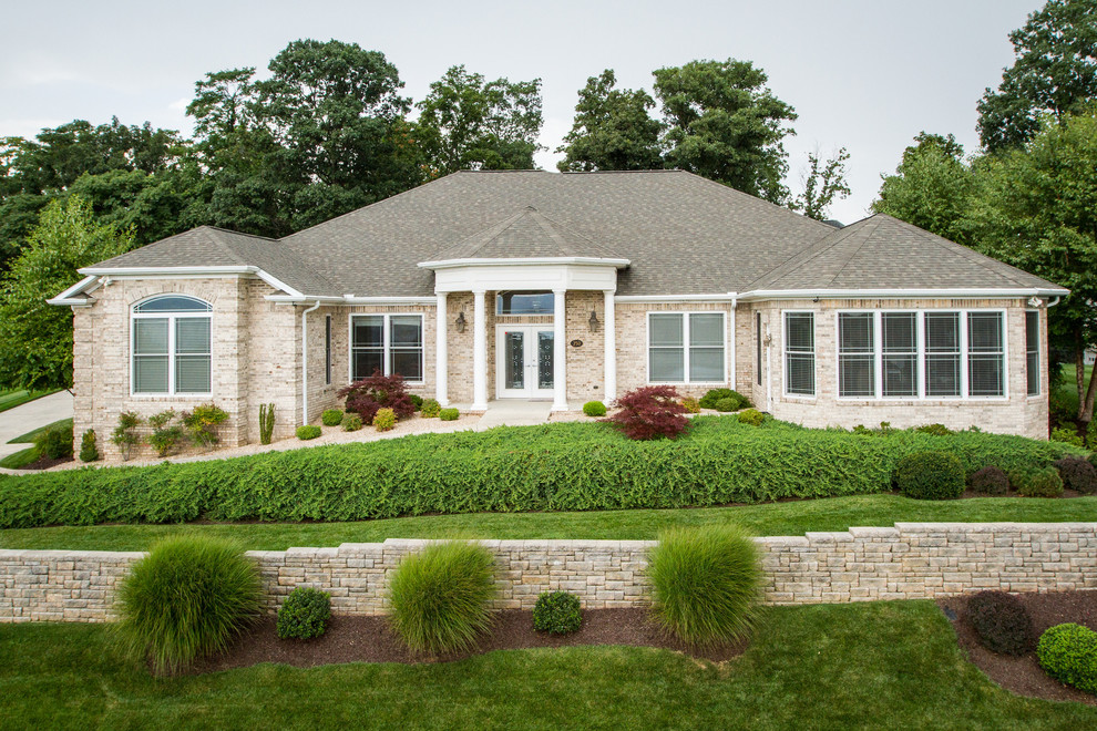 This is an example of an expansive transitional one-storey brick beige exterior in Other.