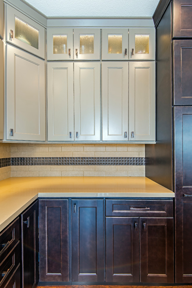 Kitchen - large transitional l-shaped medium tone wood floor kitchen idea with a farmhouse sink, brown cabinets, granite countertops, beige backsplash, subway tile backsplash, stainless steel appliances, an island and recessed-panel cabinets