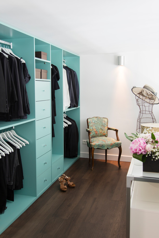 Design ideas for a large contemporary women's dressing room in Paris with open cabinets, blue cabinets and dark hardwood floors.