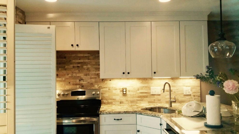 Open concept kitchen - mid-sized transitional l-shaped medium tone wood floor and brown floor open concept kitchen idea in DC Metro with an undermount sink, shaker cabinets, white cabinets, granite countertops, beige backsplash, stone tile backsplash, stainless steel appliances and a peninsula