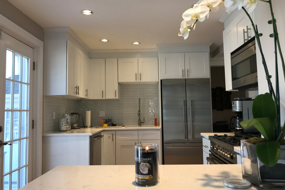 Inspiration for a small transitional l-shaped light wood floor and beige floor eat-in kitchen remodel in Bridgeport with an undermount sink, shaker cabinets, white cabinets, gray backsplash, glass tile backsplash, stainless steel appliances, no island and quartzite countertops