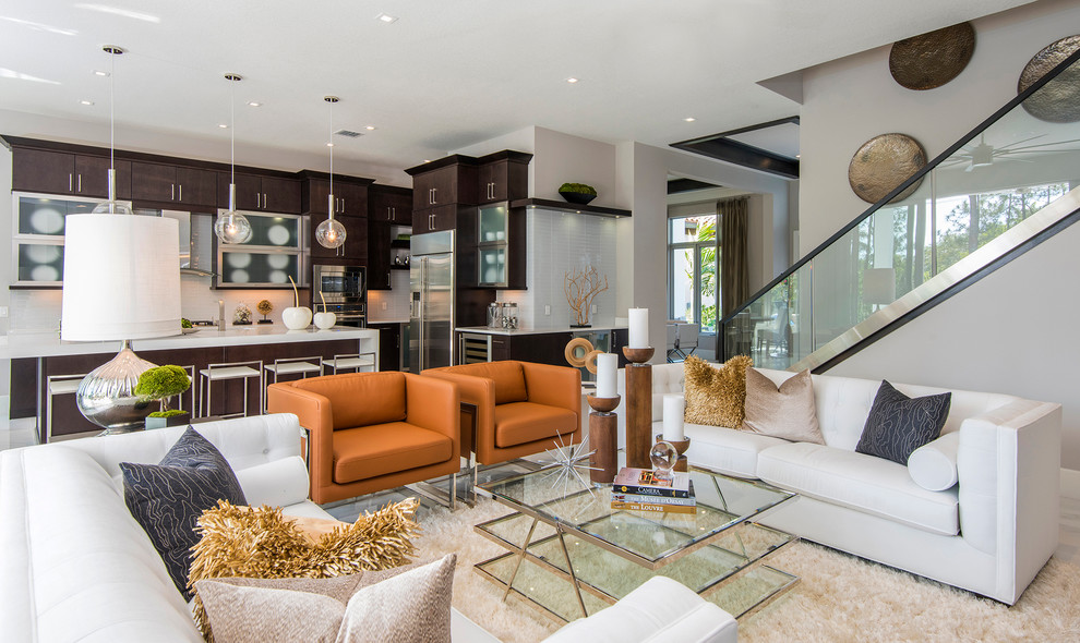 This is an example of a contemporary open concept living room in Miami with grey walls and light hardwood floors.