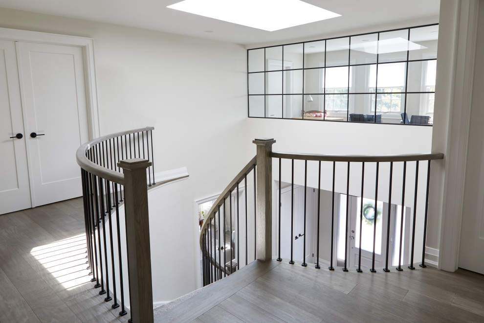 Example of a large transitional carpeted spiral wood railing staircase design in Toronto with wooden risers
