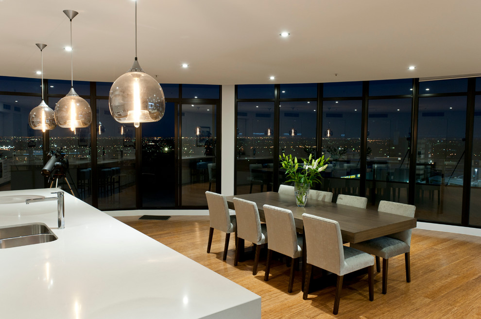 Expansive contemporary dining room in Melbourne with white walls and light hardwood floors.