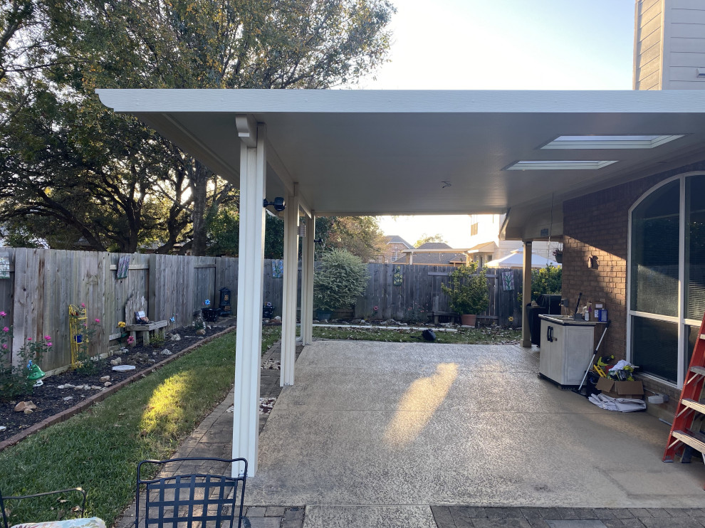 Contemporary backyard patio in Austin with stamped concrete and an awning.