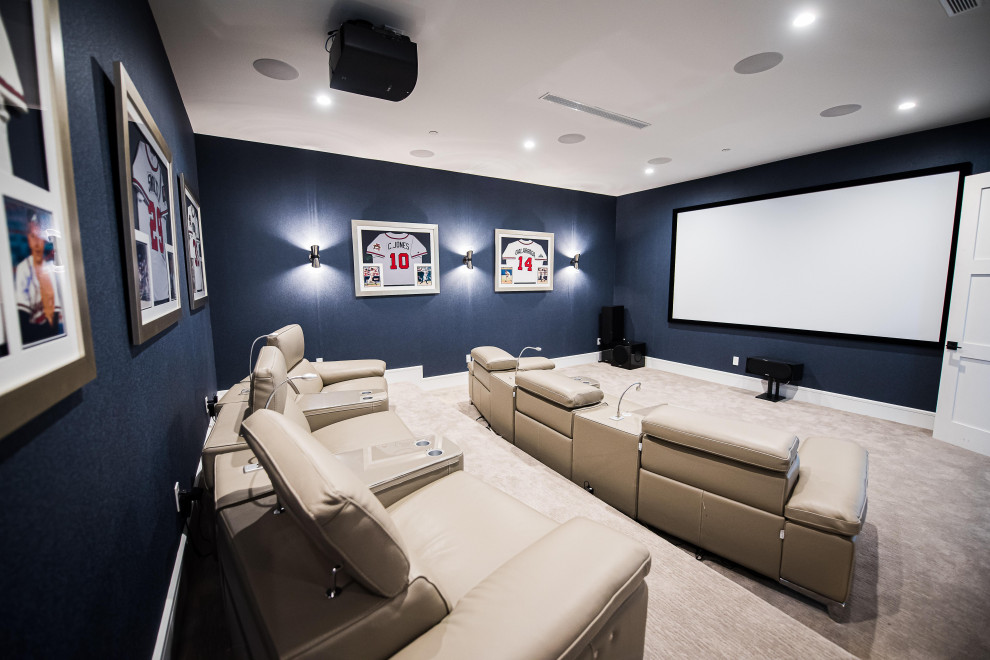 Photo of a large modern enclosed home theatre in Miami with blue walls, carpet, a projector screen and beige floor.