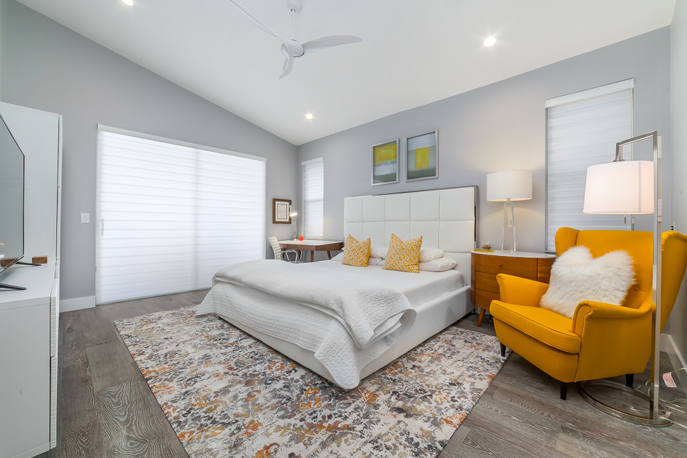 Contemporary bedroom in Miami with grey walls, medium hardwood floors, no fireplace and grey floor.