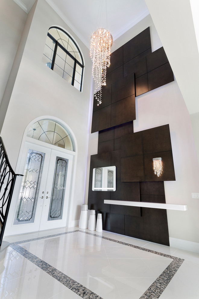 Photo of an expansive contemporary foyer in Miami with beige walls, porcelain floors, a double front door, a white front door and beige floor.