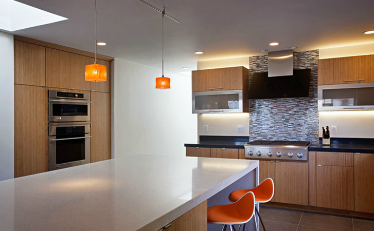Eat-in kitchen - large transitional l-shaped cement tile floor and gray floor eat-in kitchen idea with flat-panel cabinets, black backsplash, stainless steel appliances, an island, a drop-in sink, light wood cabinets, quartz countertops and ceramic backsplash