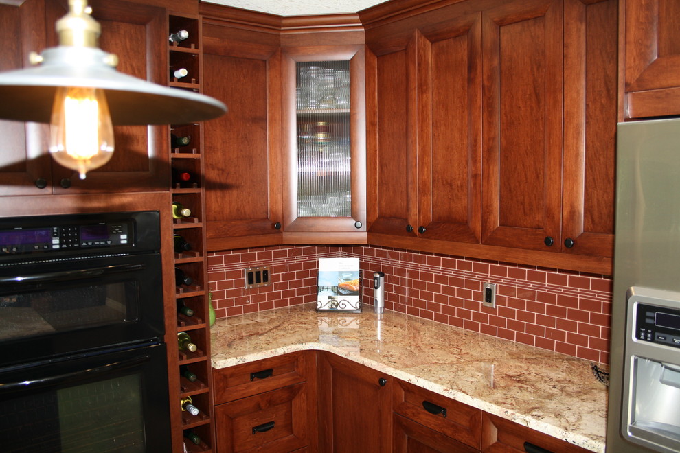 Example of a mid-sized transitional u-shaped ceramic tile eat-in kitchen design in Calgary with an undermount sink, flat-panel cabinets, brown cabinets, granite countertops, red backsplash, subway tile backsplash, stainless steel appliances and an island