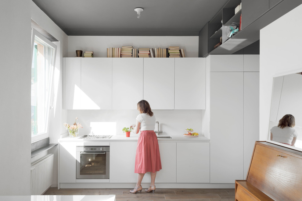Design ideas for a scandinavian single-wall kitchen in Other with flat-panel cabinets, white cabinets, quartz benchtops, white splashback, porcelain floors, no island, white benchtop and an undermount sink.