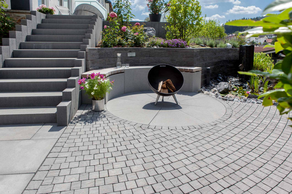Photo of a country garden with with rock feature and concrete pavers.