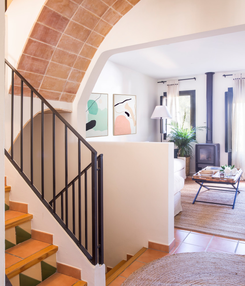 Foto de escalera de estilo de casa de campo con escalones de terracota, contrahuellas con baldosas y/o azulejos y barandilla de metal