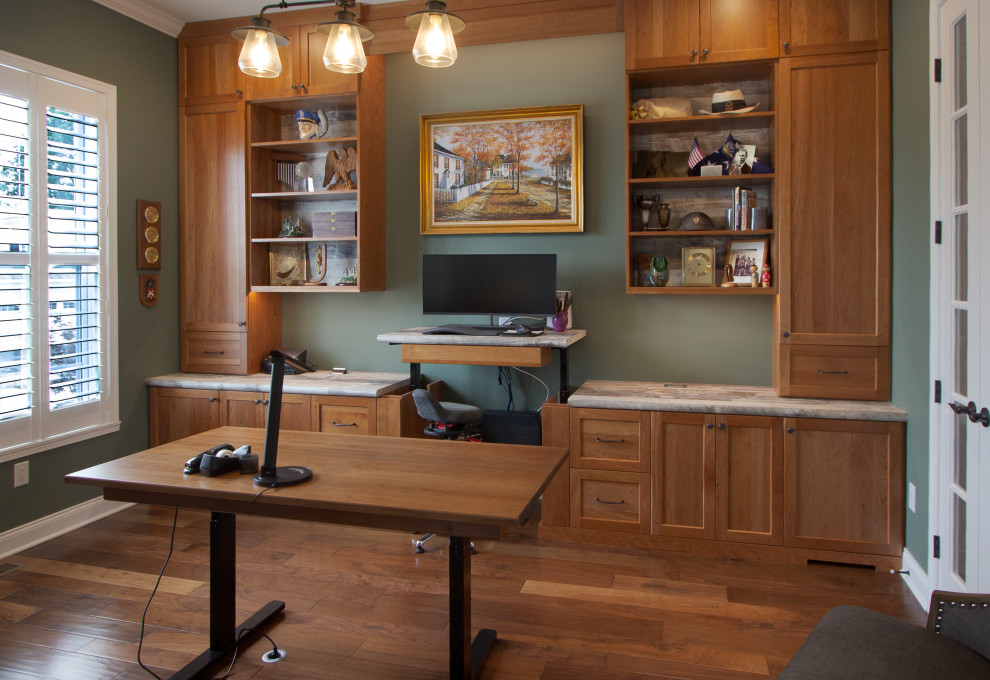 Imagen de despacho clásico de tamaño medio con paredes verdes, suelo de madera en tonos medios, escritorio empotrado y suelo marrón