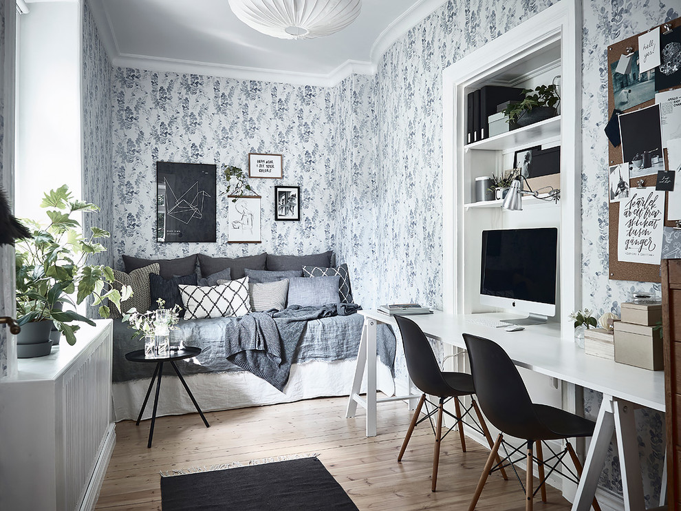 Traditional home office in Gothenburg with beige floor, multi-coloured walls, a freestanding desk and light hardwood floors.