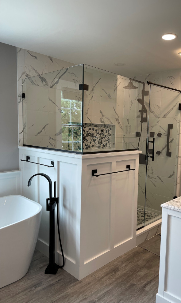 This is an example of a mid-sized country master bathroom in Other with shaker cabinets, white cabinets, a freestanding tub, a corner shower, a two-piece toilet, multi-coloured tile, ceramic tile, grey walls, laminate floors, an undermount sink, engineered quartz benchtops, multi-coloured floor, a hinged shower door, multi-coloured benchtops, a shower seat, a double vanity, a built-in vanity and decorative wall panelling.