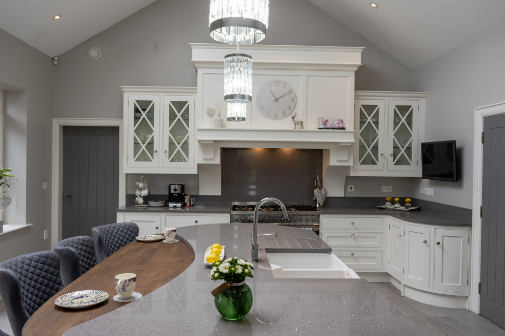 Inspiration for a large traditional eat-in kitchen in Other with a farmhouse sink, shaker cabinets, white cabinets, granite benchtops, grey splashback, granite splashback, stainless steel appliances, with island, grey floor and grey benchtop.