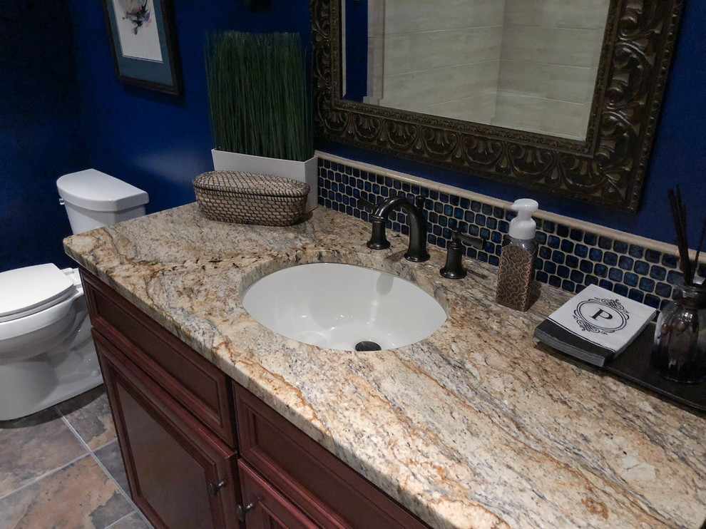 Inspiration for a traditional 3/4 bathroom in Philadelphia with brown cabinets, a corner shower, a one-piece toilet, blue walls, an integrated sink, engineered quartz benchtops, a hinged shower door, multi-coloured benchtops, a single vanity and a freestanding vanity.