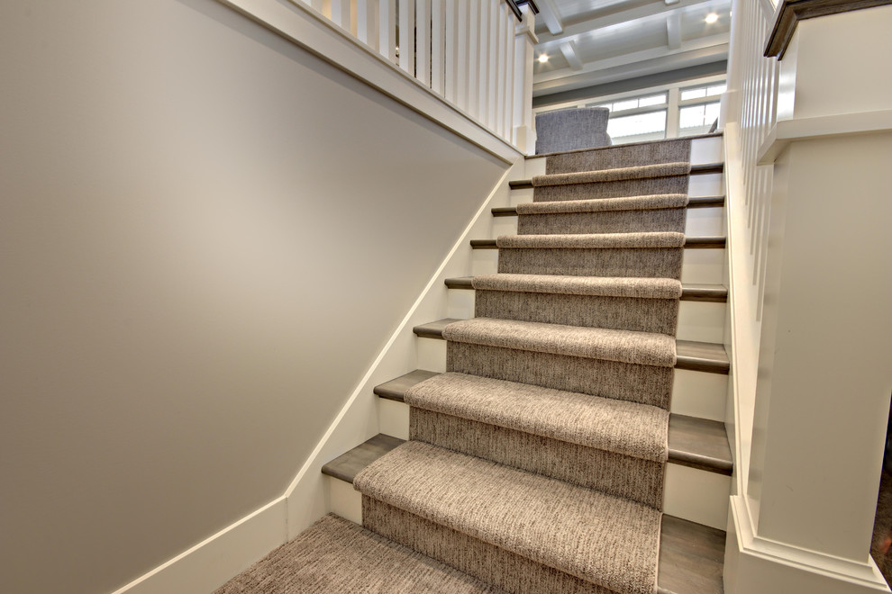 Design ideas for a mid-sized contemporary carpeted u-shaped staircase in Grand Rapids with carpet risers and wood railing.