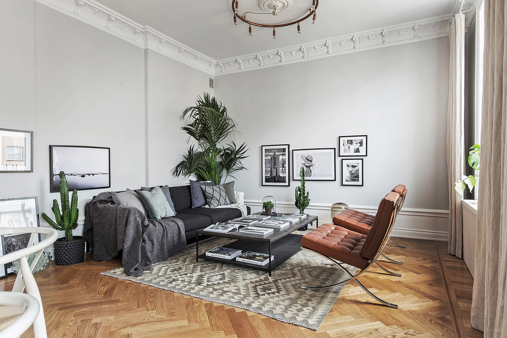Large scandinavian formal open concept living room in Stockholm with grey walls, medium hardwood floors, no fireplace and no tv.