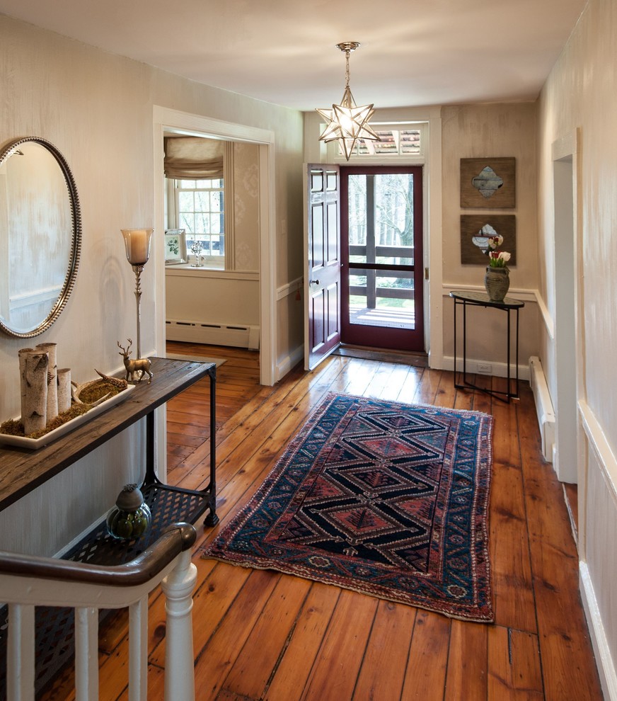 This is an example of a mid-sized country foyer in Philadelphia with beige walls, medium hardwood floors, a single front door and a red front door.