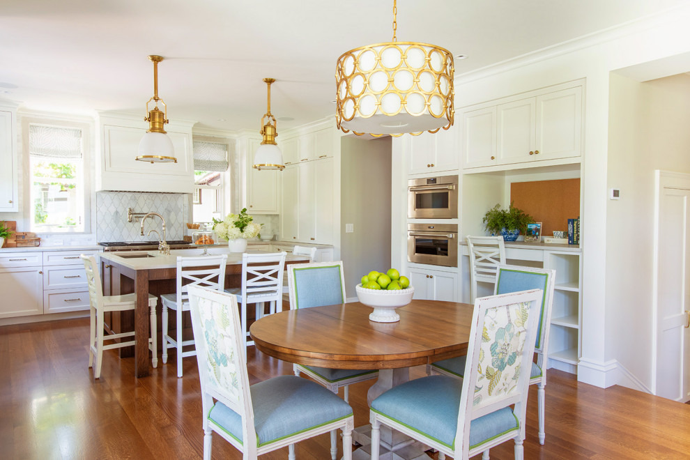 Kitchen - transitional medium tone wood floor and brown floor kitchen idea in Boston with recessed-panel cabinets, white cabinets, gray backsplash, mosaic tile backsplash, stainless steel appliances, an island and gray countertops
