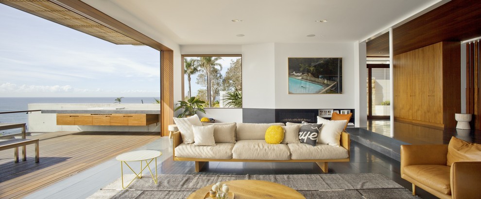This is an example of a large contemporary open concept living room in Sydney with white walls, slate floors, a ribbon fireplace, a concrete fireplace surround and a wall-mounted tv.