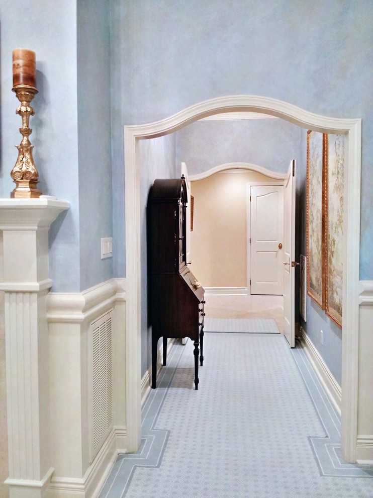 Large traditional hallway in New Orleans with blue walls, marble floors and blue floor.