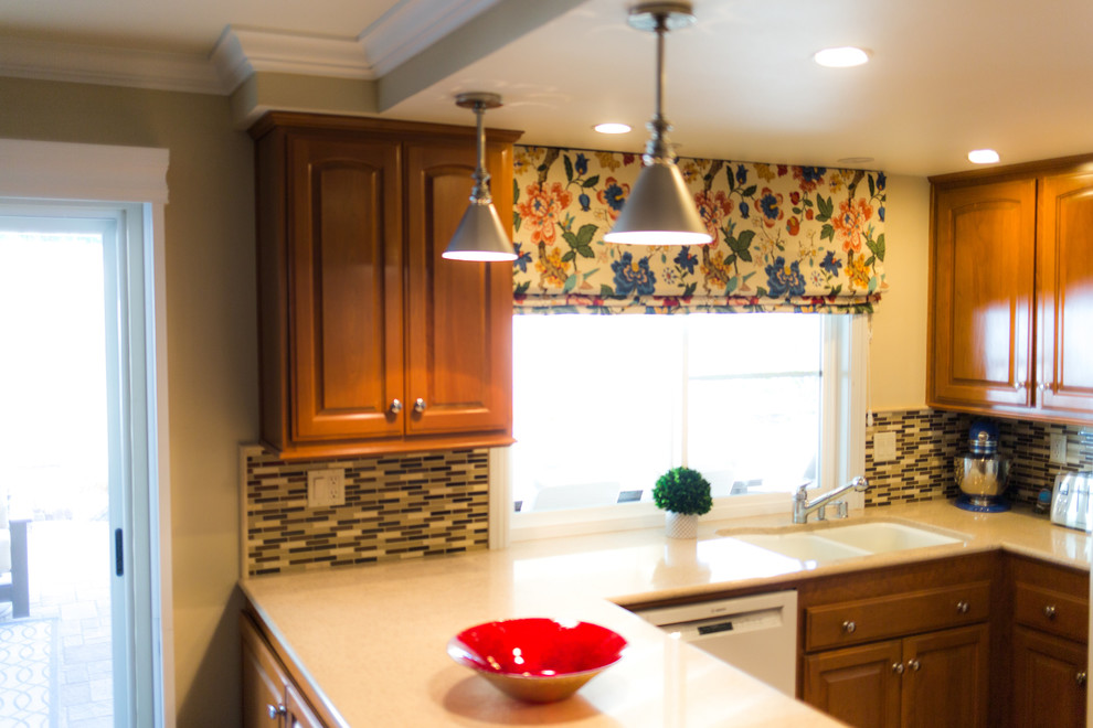 Inspiration for a mid-sized transitional u-shaped eat-in kitchen remodel in Orange County with a double-bowl sink, raised-panel cabinets, medium tone wood cabinets, quartzite countertops, beige backsplash, matchstick tile backsplash, white appliances and a peninsula