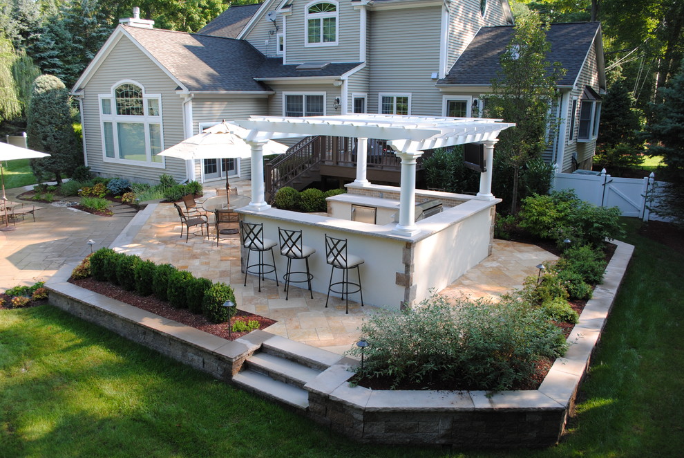 Photo of a mid-sized traditional backyard patio in New York with an outdoor kitchen, tile and a pergola.