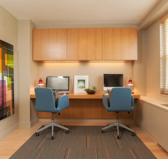 Mid-sized modern study room in Other with beige walls, light hardwood floors and a built-in desk.