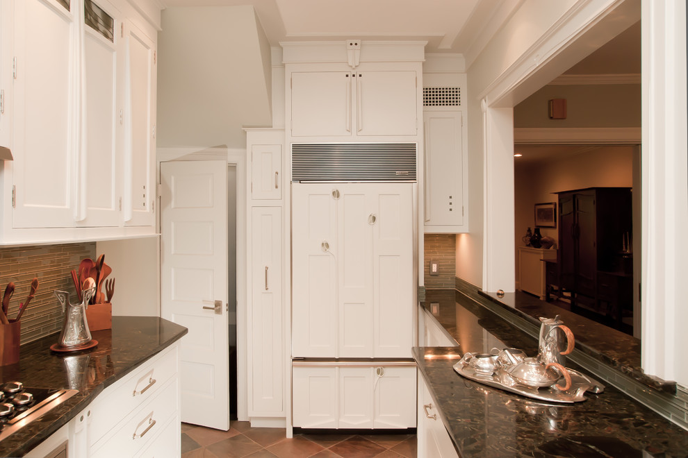 Photo of a small arts and crafts u-shaped kitchen pantry in DC Metro with an undermount sink, flat-panel cabinets, white cabinets, granite benchtops, green splashback, glass tile splashback, panelled appliances and slate floors.