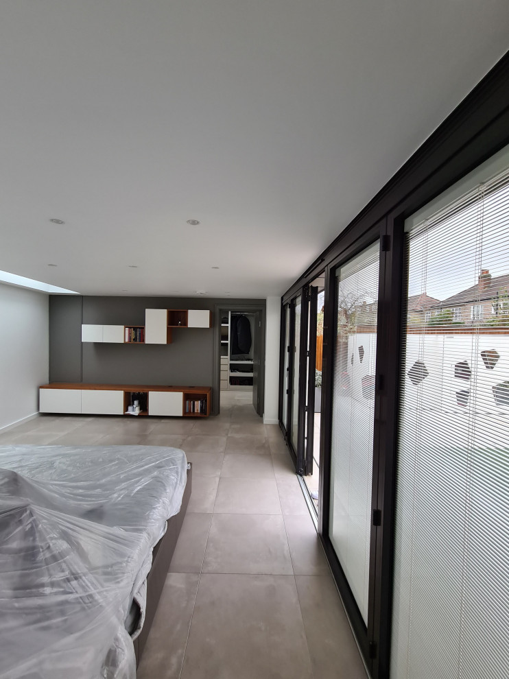 Foto di una grande camera matrimoniale minimalista con pareti bianche, pavimento in gres porcellanato, pavimento beige e soffitto ribassato
