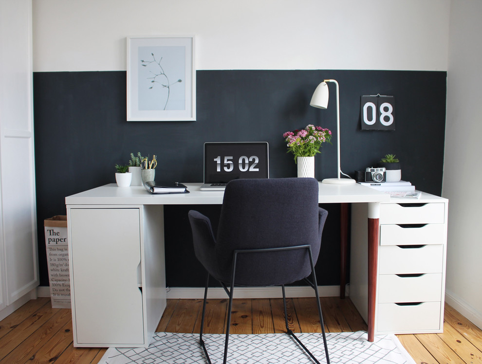 Photo of a small scandinavian study room in Berlin with white walls, light hardwood floors, a freestanding desk and no fireplace.