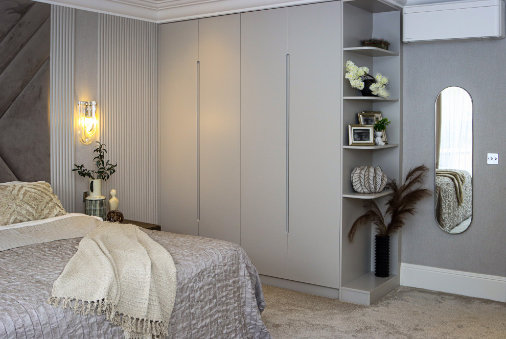 Example of a mid-sized trendy master carpeted, beige floor and wall paneling bedroom design in London with beige walls